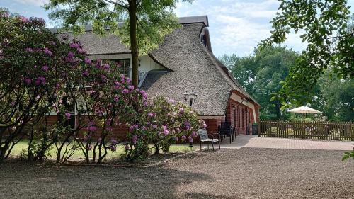 a house with purple flowers in front of it at De Leev - Landhaus Lübbertsfehn in Ihlow
