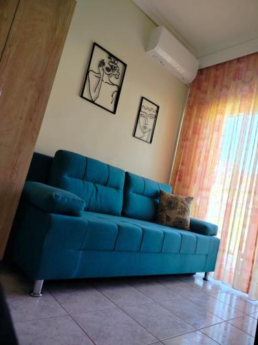 a blue couch sitting in a living room at Calypso Seaside Apartment in Paleo Tsifliki