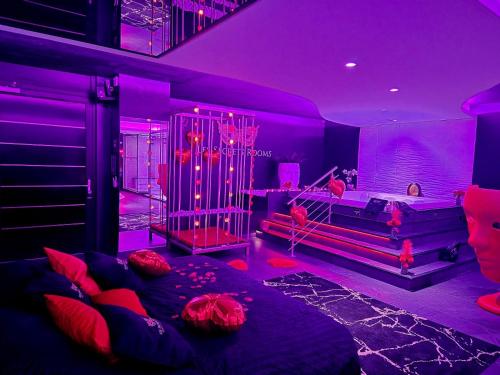 ein lila Zimmer mit einem Bett und einem Sofa in der Unterkunft Les Secrets Rooms in Hagondange