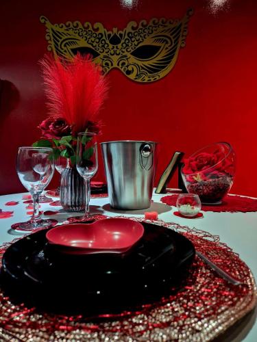 a table with a plate with a masquerade mask on it at Les Secrets Rooms in Hagondange
