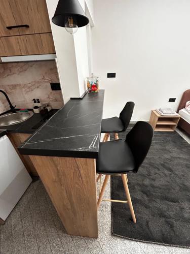 a kitchen with a black counter and two chairs at Monte Cristo in Valjevo