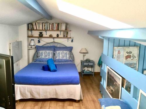 una camera da letto con letto blu in mansarda di Petite maison bleue Dune du Pyla 4 personnes 2 vélos a La Teste-de-Buch