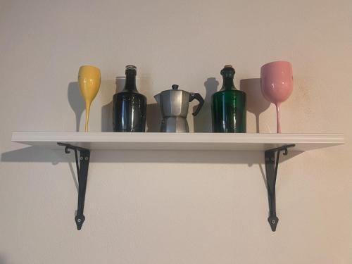 a shelf with different colored vases and wine glasses at Terasy Sedlec in Sedlec