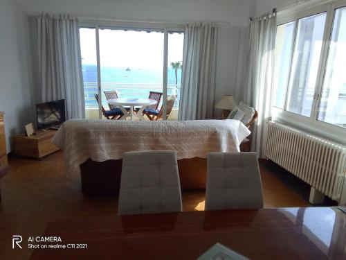 une chambre avec un lit, une table et des chaises dans l'établissement Bel appartement face mer, à Juan-les-Pins