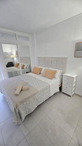 een slaapkamer met een groot bed met twee kussens erop bij Benalmadena Minerva Apartamento con gran piscina in Benalmádena