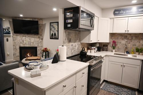 a kitchen with white cabinets and a stove top oven at Cozy Ski Condo in Waterville Valley