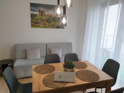 a dining room with a table with a laptop on it at Apartamenty Wakacyjne Historie in Międzylesie
