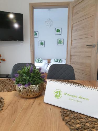 a table with a sign on it with two chairs at Apartamenty Wakacyjne Historie in Międzylesie
