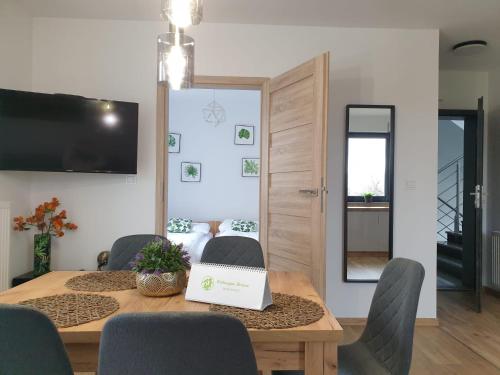 a dining room with a table with a laptop on it at Apartamenty Wakacyjne Historie in Międzylesie