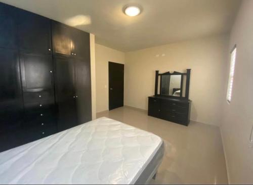 a bedroom with a bed and a dresser and a mirror at departamento céntrico para visitas in Monclova