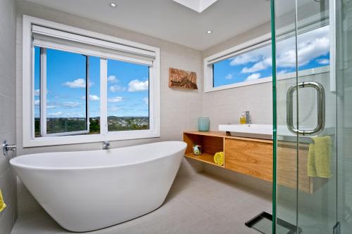 a bathroom with a large white tub and a window at The City Cottage in Auckland