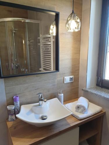 a bathroom with a white sink and a mirror at Apartamenty Wakacyjne Historie in Międzylesie