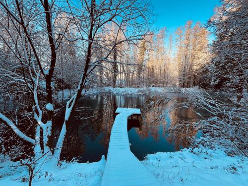a bridge over a river in the snow at La Cabana FaVa in Chaumont-Gistoux