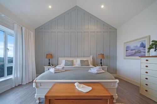 a bedroom with a large bed and a wooden table at Waterstone, Narin Portnoo in Portnoo
