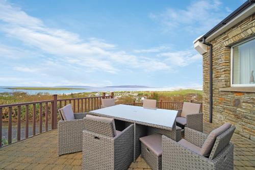 a patio with a table and chairs on a balcony at Waterstone, Narin Portnoo in Portnoo