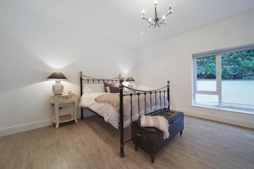 a bedroom with a bed and a table and a window at Waterstone, Narin Portnoo in Portnoo
