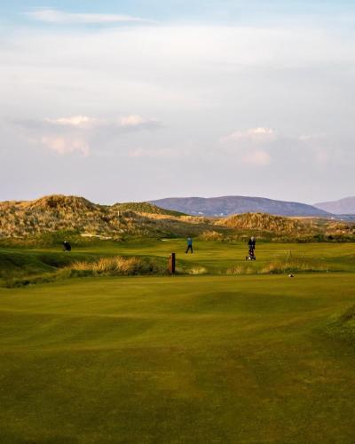 a view of a golf course with mountains in the background at Waterstone, Narin Portnoo in Portnoo