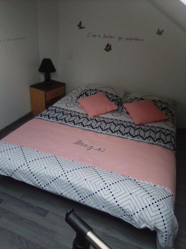 - un lit avec 2 oreillers roses dans l'établissement Béniguet, à Paimpol