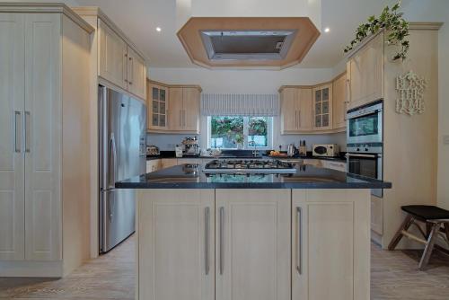 a kitchen with white cabinets and a black counter top at Waterstone, Narin Portnoo in Portnoo