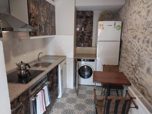 a small kitchen with a sink and a refrigerator at Yeşiltepe Budget in Konak