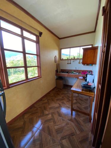 a kitchen with a table and two windows in a room at Valles of Osa in Palmar Sur