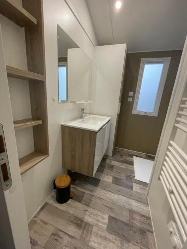 a bathroom with a sink and a mirror at Mobilhome bord du lac in Parentis-en-Born