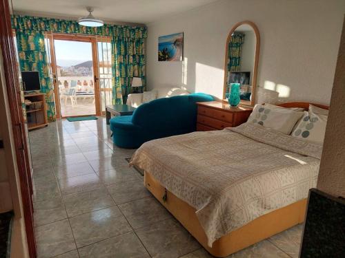 a bedroom with a bed and a blue couch at Best4Buck in Los Cristianos