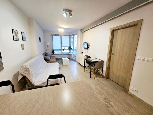a living room with a bed and a desk at Extra Green Kabaty Apartament nr 5 in Warsaw