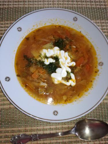 a bowl of soup on a table with a spoon at Villa River Rose in Jõesuu
