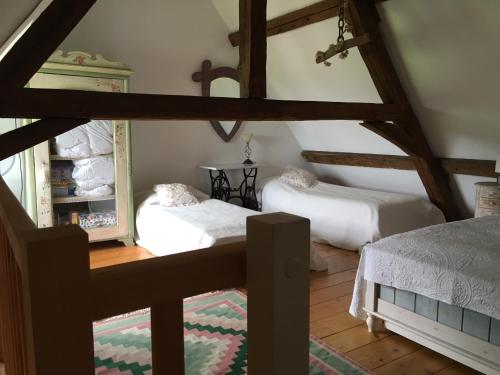 Cette chambre mansardée comprend 2 lits et un miroir. dans l'établissement The Orangery apartment, Chateau de la Trousse, à Ocquerre