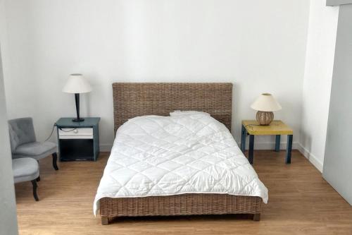 - une chambre avec un lit, deux tables et une chaise dans l'établissement Appartement charmant à Quiberon, 45 m², vue sur jardin, à Quiberon