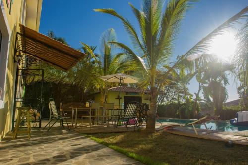 a patio with a table and chairs next to a pool at Wipeout Hostel in Jacó