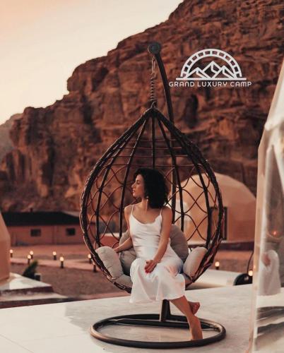 a woman is sitting in a round swing at Grand luxury rum in Wadi Rum