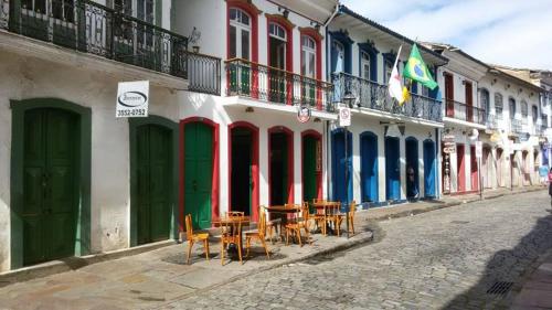 a row of buildings with tables and chairs on a street at Varanda Pouso e Arte in Ouro Preto