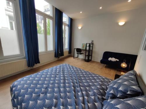 a bedroom with a bed and a couch and windows at Nice Flat Grand Place in Brussels