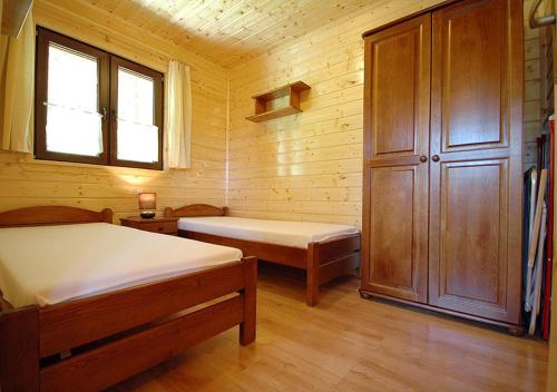a small room with two beds and a window at Domki Letniskowe Wydma in Bobolin