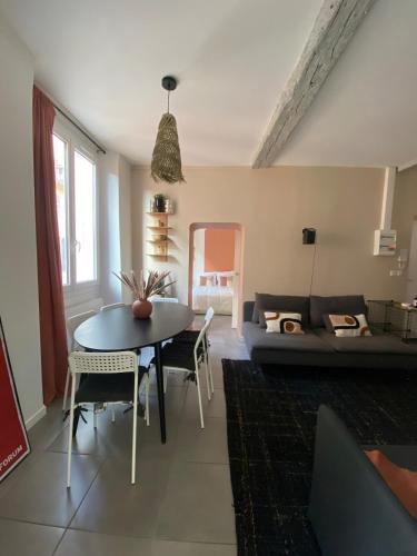un salon avec une table et un canapé dans l'établissement Appartement proche du port, à Toulon
