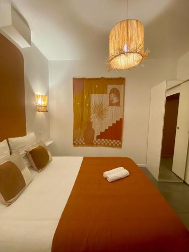 - une chambre avec un grand lit blanc et un lustre dans l'établissement Appartement proche du port, à Toulon