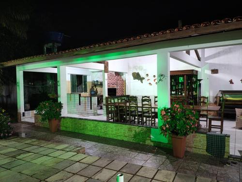 a green and white restaurant with tables and chairs at Casa de Praia para COP 30 in Belém