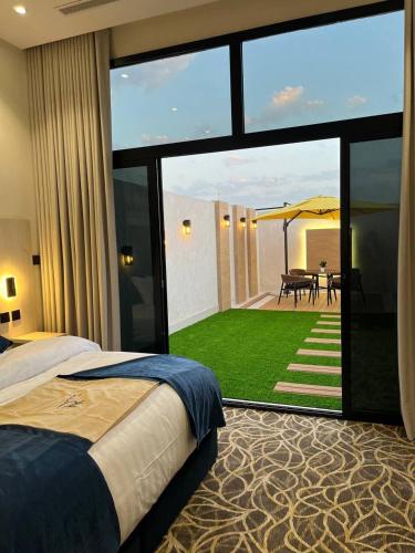 a bedroom with a large window with a view of a garden at Tara Plus Hotel in Jeddah