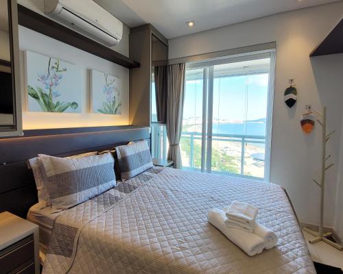 ein Schlafzimmer mit einem Bett und Meerblick in der Unterkunft BookSantos Unlimited 2506 Paraíso Vista Mar 2dor in Santos
