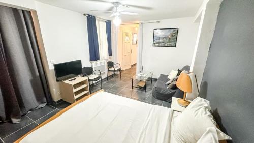 un salon avec un lit et une télévision dans l'établissement Cosy appartement proche Paris - aéroport CDG - RER D à 8 min à pied, à Goussainville