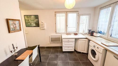 une cuisine avec un évier et une machine à laver dans l'établissement Cosy appartement proche Paris - aéroport CDG - RER D à 8 min à pied, à Goussainville