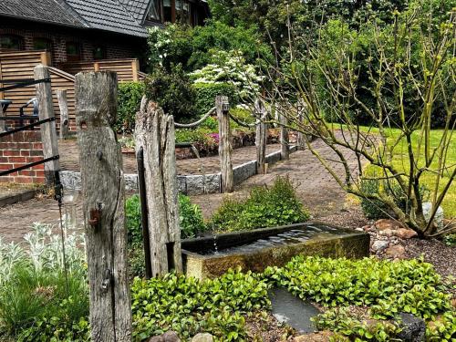 a garden with a wooden fence and some plants at Gästehaus Peerhus Dönsel - Deensten in Rehden