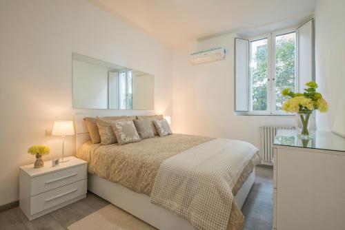 ein weißes Schlafzimmer mit einem Bett und einem Spiegel in der Unterkunft Vatican Holiday Apartment 317 in Rom