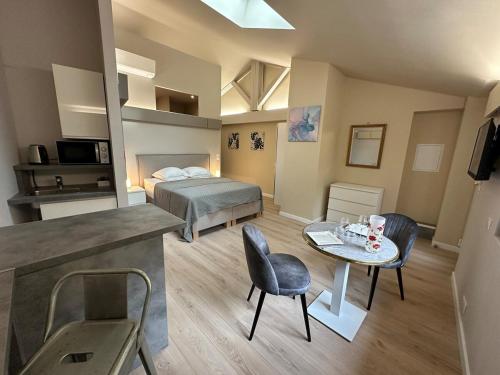 a bedroom with a bed and a table and chairs at L'Esquisse Coquelicot - Parking Clim Netflix Canal in Milhaud