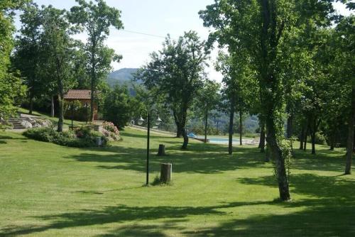 a park with green grass and trees and a sign at Fattoria di Arsicci in Caprile