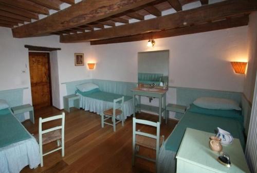 a bedroom with two beds and a table and a desk at Fattoria di Arsicci in Caprile