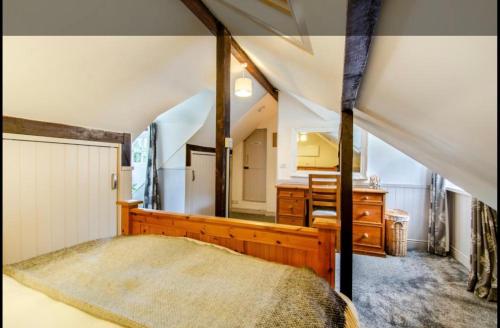 a bedroom with a bed and a sink and a mirror at Stable boys cottage in Sedgeberrow