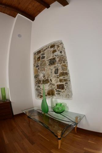 a room with a glass table and a stone wall at Tenuta Valdomini in Attimis